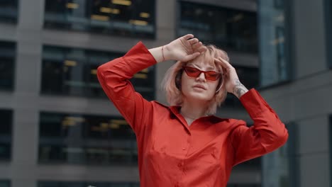 stylish woman in red shirt and sunglasses in a city