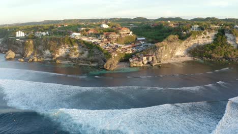 Vista-Aérea-De-Paralaje-Del-Famoso-Lugar-De-Surf-Suluban-Beach-Durante-La-Puesta-De-Sol,-Uluwatu-Bali-Indonesia