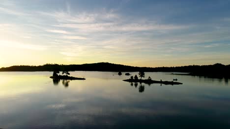 Feuer-Am-Himmel,-Während-Eine-Drohne-Während-Dieses-Erstaunlichen-Sonnenaufgangs-In-Colorado-Sanft-über-Einen-Spiegelsee-Fliegt