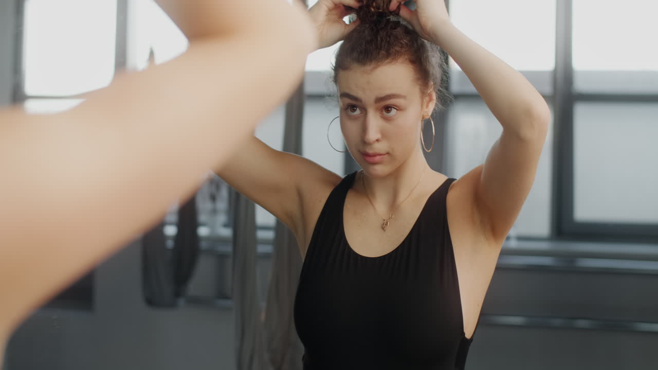 mujer peinando el cabello delante del espejo