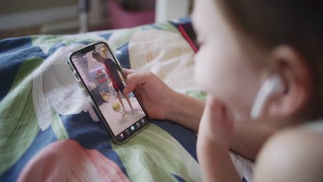 niño haciendo una llamada de video en el teléfono inteligente en la cama