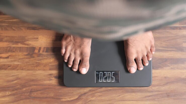 Man Weighing Himself on a Digital Scale