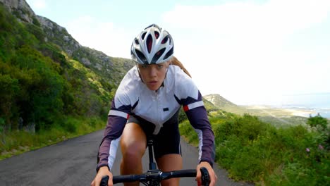 female cyclist cycling on a countryside road 4k