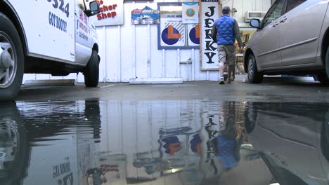 man jumping over water puddle at a store in ojai california