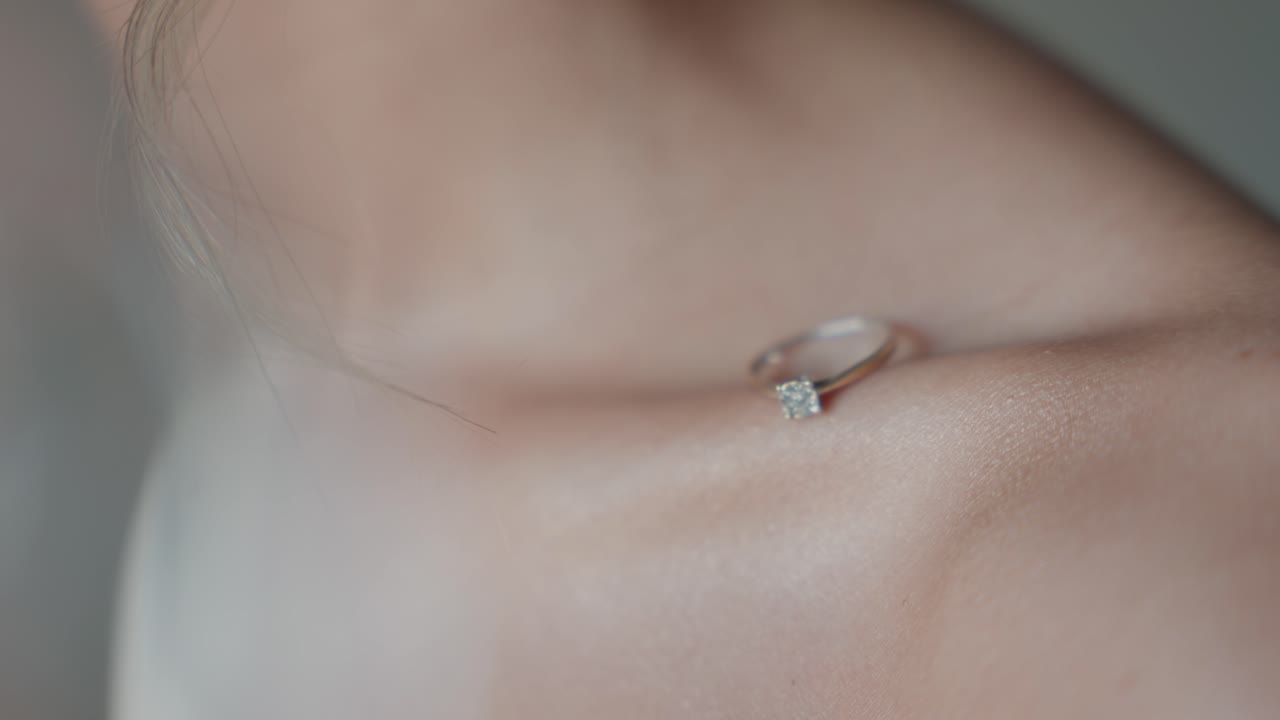Soft close up of engagement ring on a woman’s collarbone