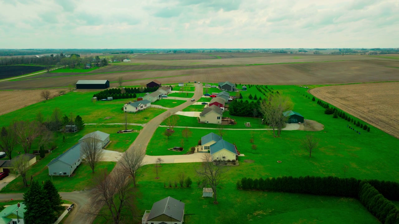 Stille beboelseskvarter i Brandon, Iowa, der viser moderne huse, der grænser direkte op til store landbrugsmarker.