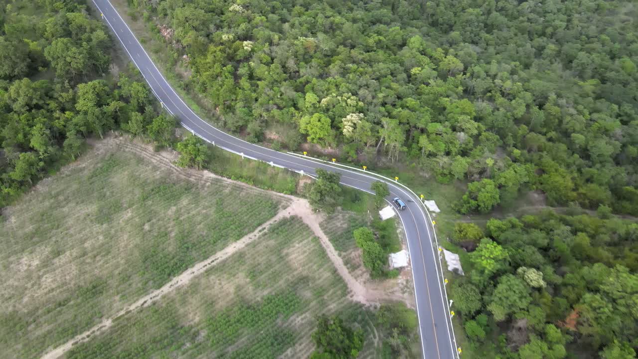 Aerial Drone Footage of Vehicles moving between trees in a forest in Lopburi Province, Thailand.
