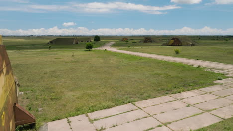 hangars and runways of abandoned shiraki military airbase in grassy plain