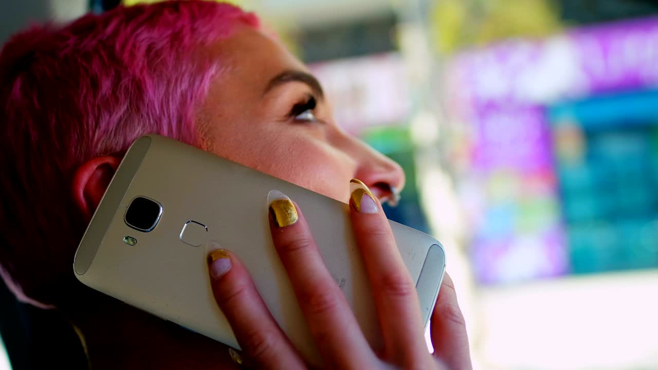mujer de cabello rosa hablando por teléfono móvil en el coche 4k