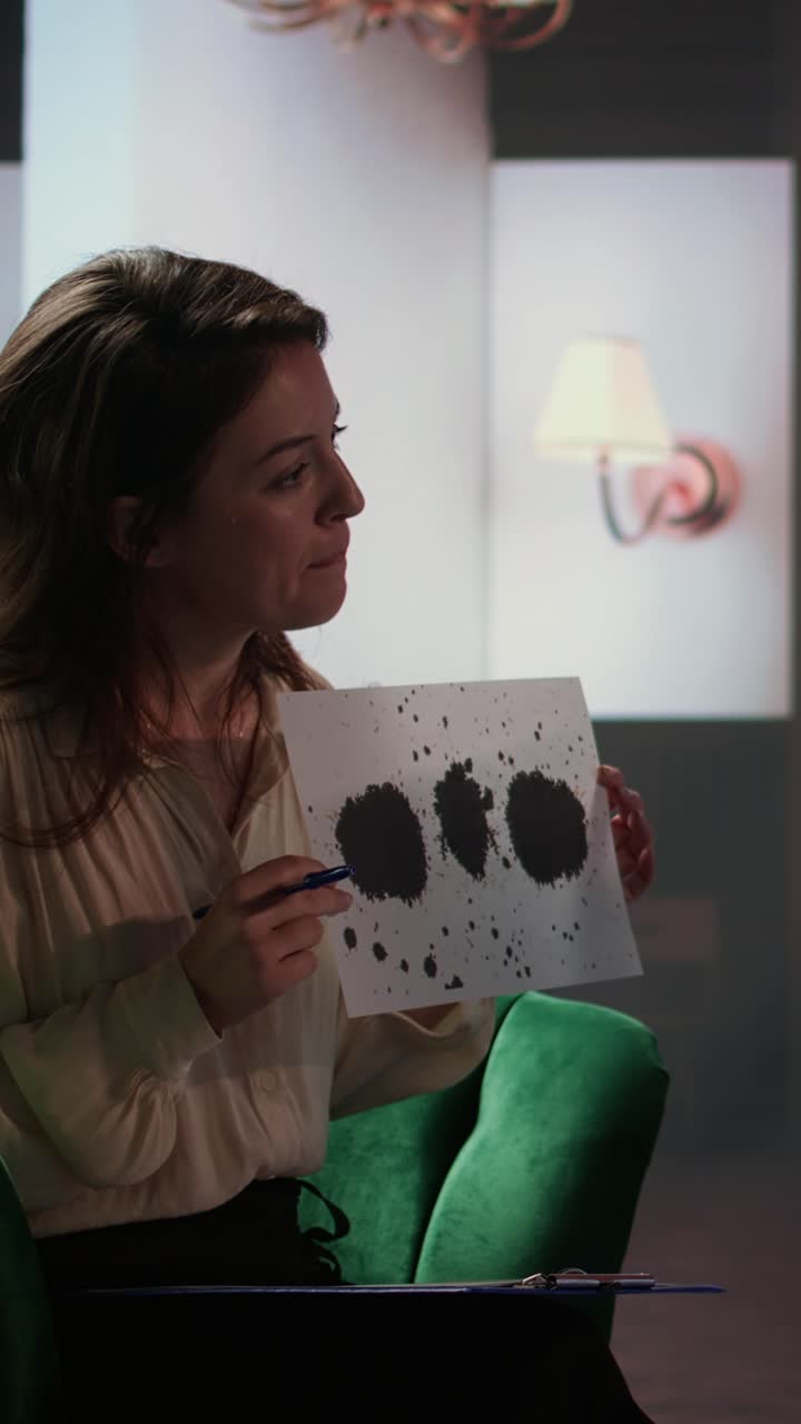 Donna che tiene il test delle macchie di Rorschach durante una sessione di terapia