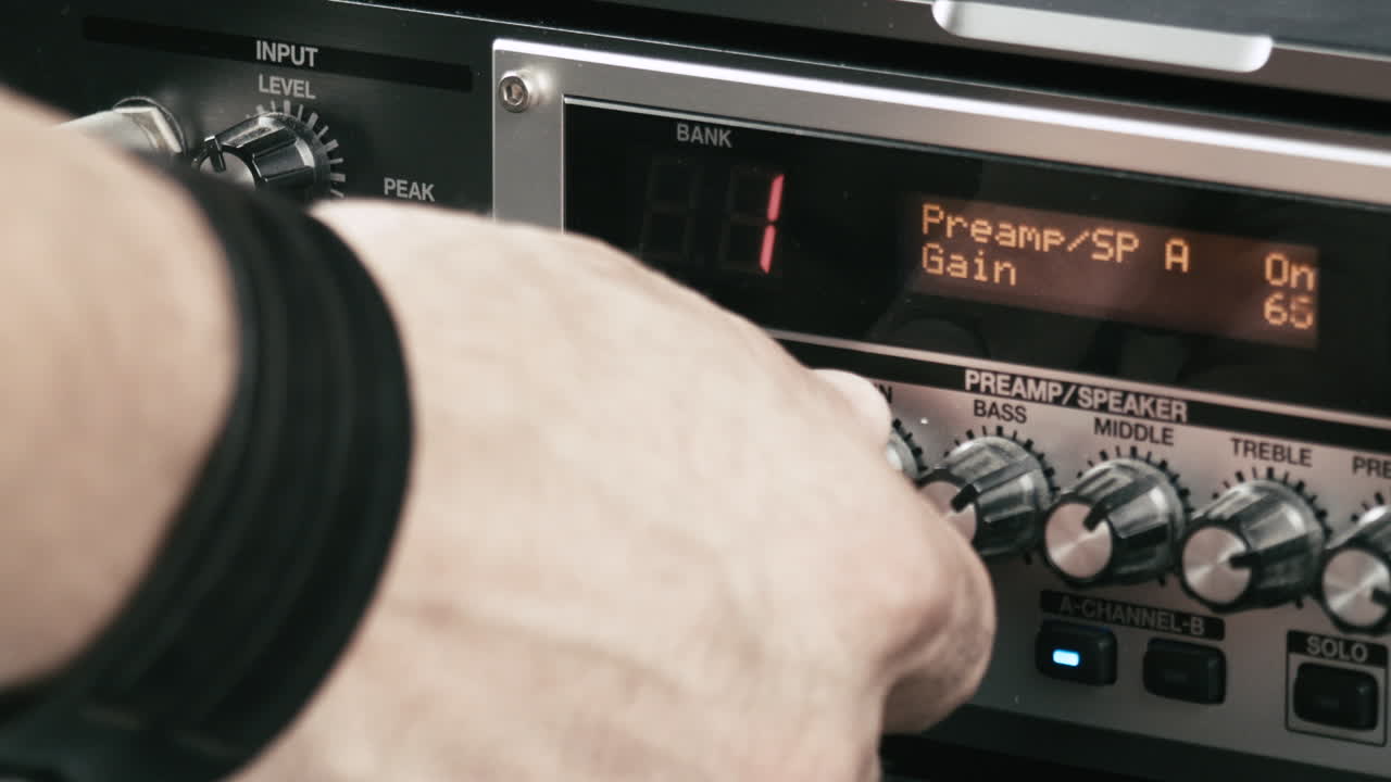 음악가의 손이 기타 프리앰프 멀티 효과의 레벨을 설정합니다.