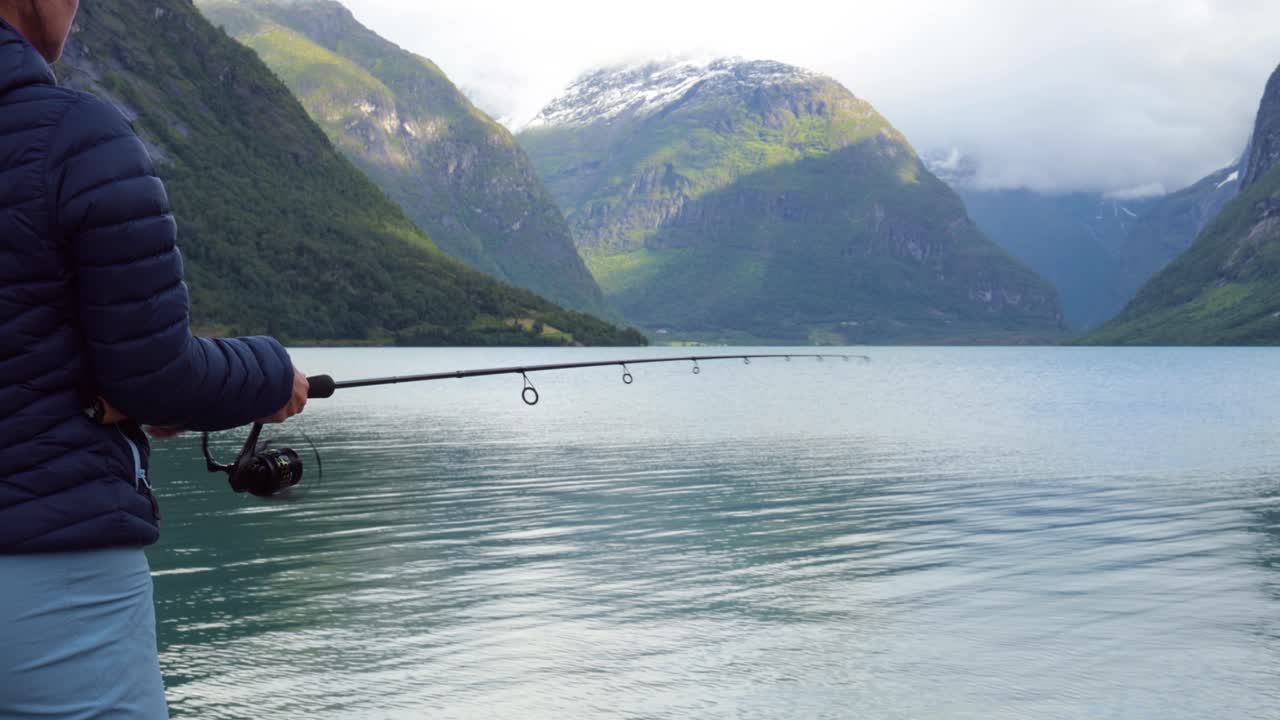 Woman fishing on Fishing rod spinning in Norway.
