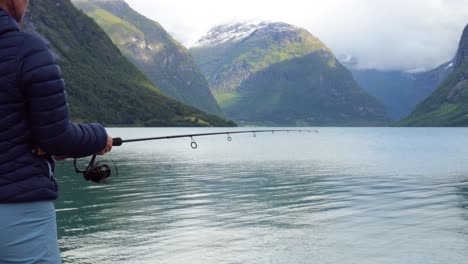 Woman-fishing-on-Fishing-rod-spinning-in-Norway.