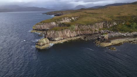 drone shot flying around rock formations on the coast of the applecross peninsula in the scottish highlands.