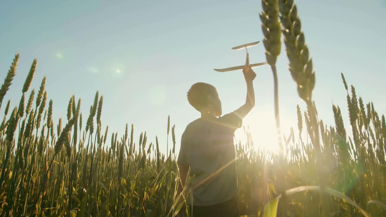 Child Playing with Toy Airplane in Wheat Field at Sunset