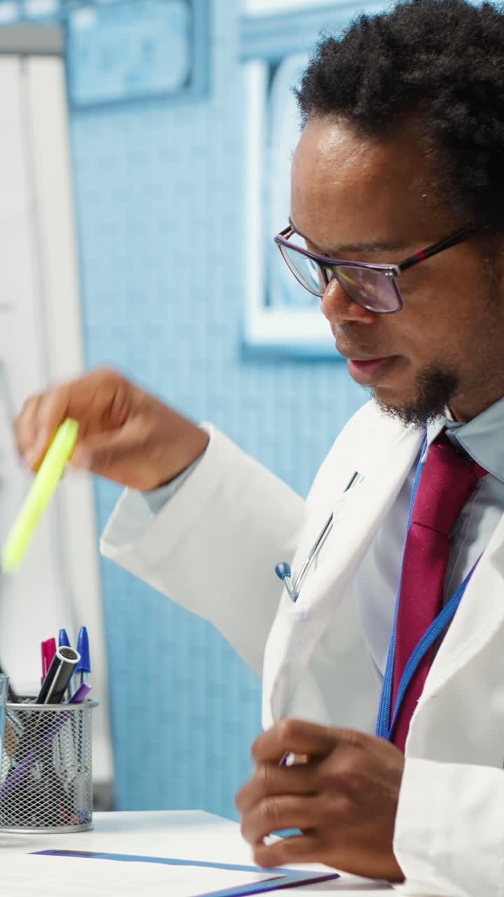 African American Doctor Writing and Highlighting Medical Documents