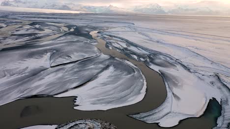 drohnenflug über landschaft mit erstem schnee, über gletscherfluss bei skaftafell in südisland