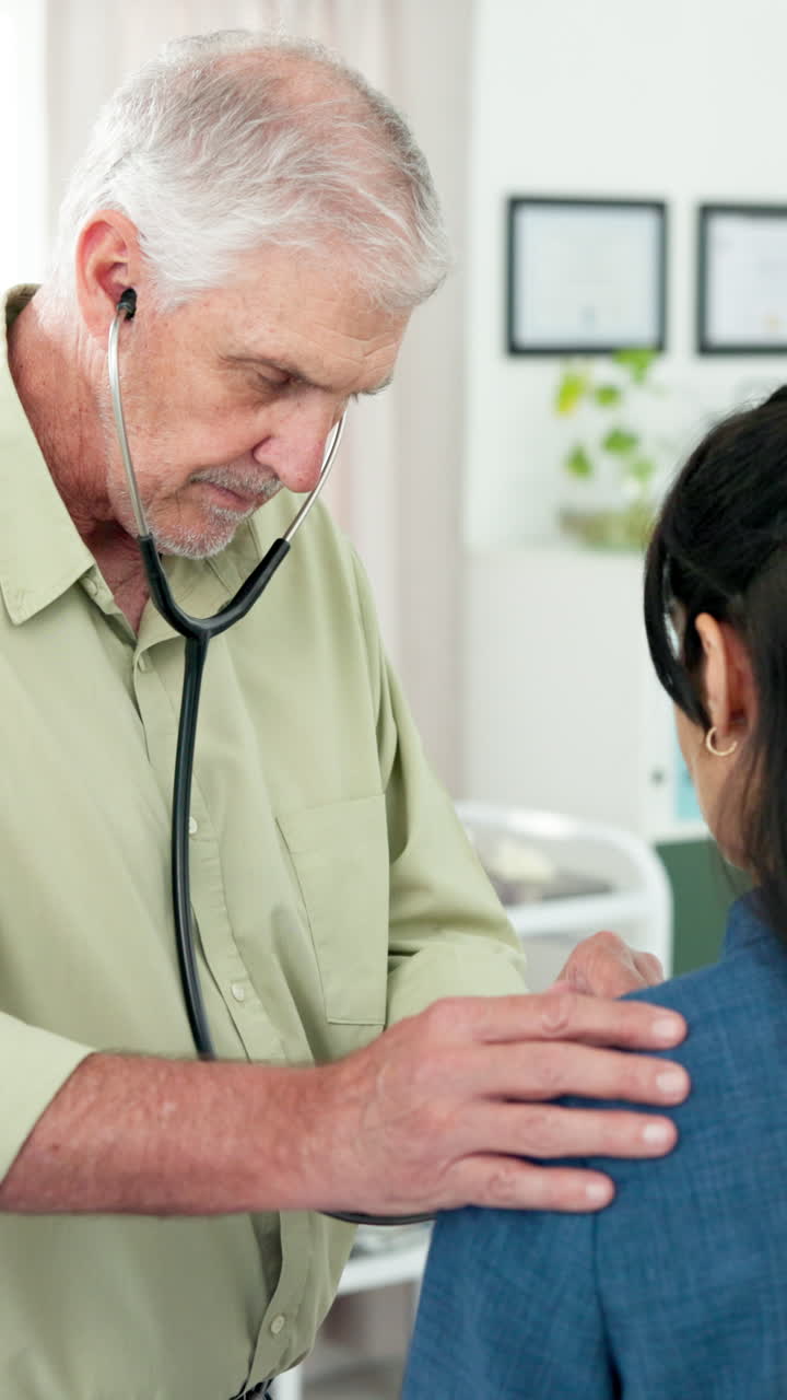 Senior Doctor Examining Female Patient with Stethoscope in Clinic