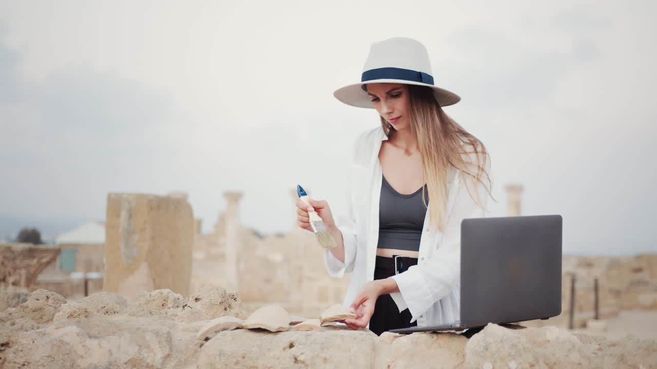 arqueólogo trabajando en un sitio antiguo con una computadora portátil