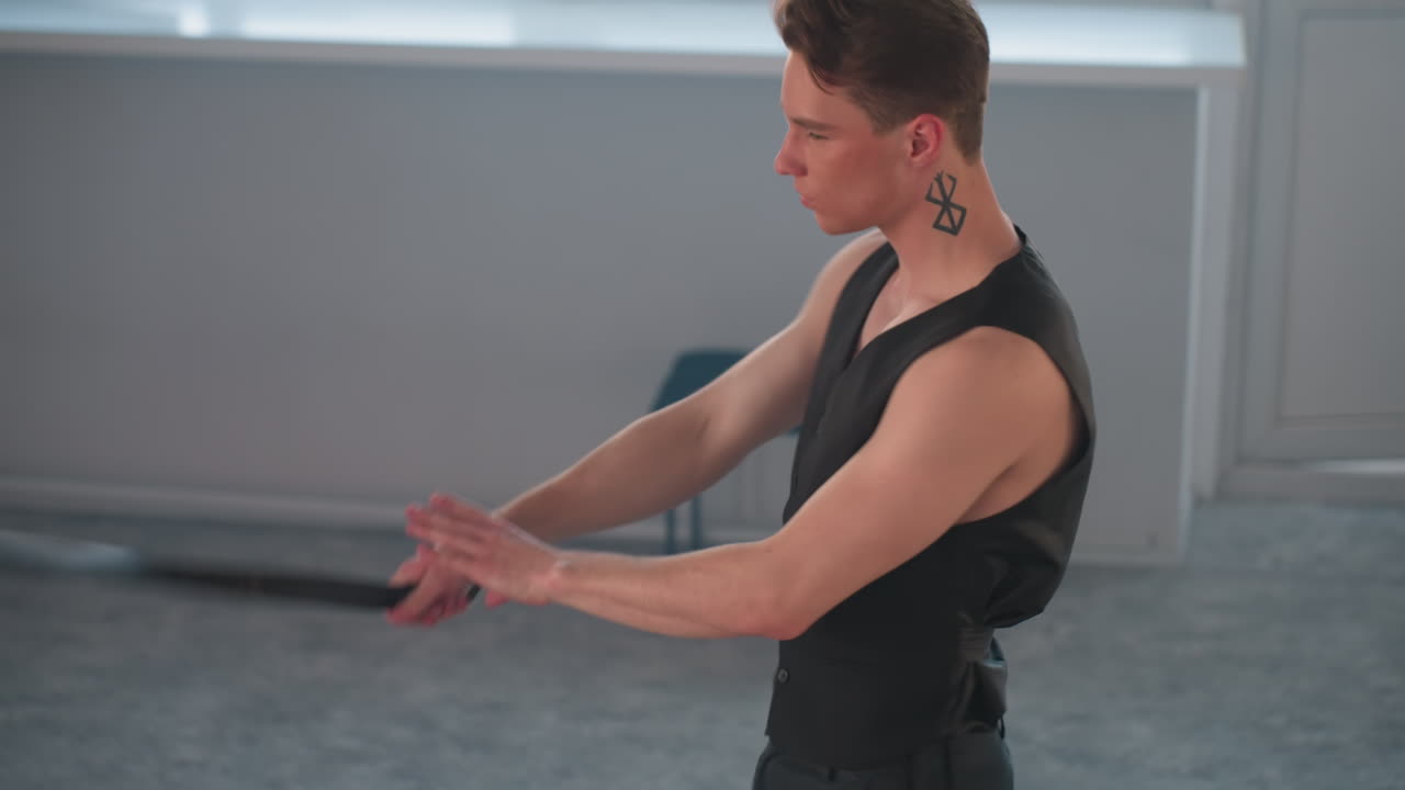 skilled dancer flips belt around neck with fluid movement styling elegant choreography in mirrored studio with stool against wall and soft natural light capturing dynamic motion and confident flair