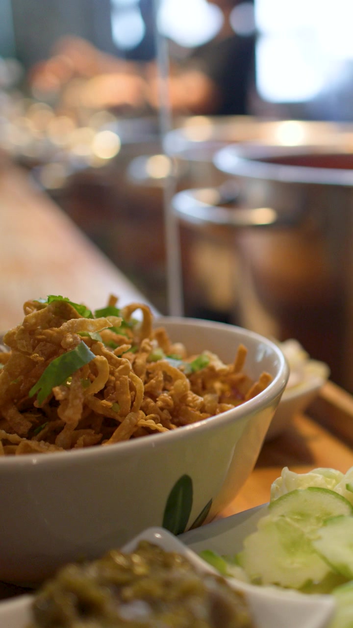 Close-up of traditional Northern Thai Khao Soi curry noodles with slow camera pull back