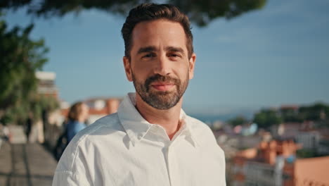 portrait smiling  man taking off sunglasses standing on sunny viewpoint