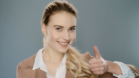 business woman showing thumbs up on grey background