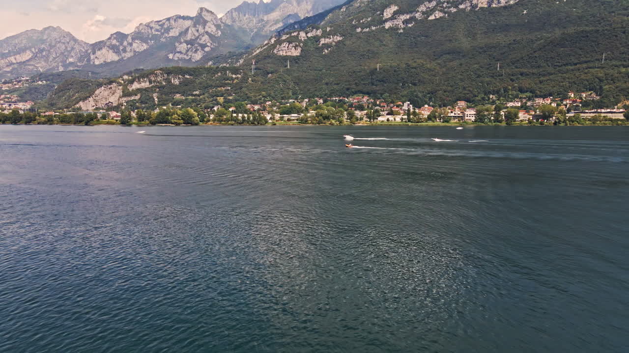 hermoso lago como con barcos navegando durante el día soleado de verano en el norte de italia - toma aérea de drones
