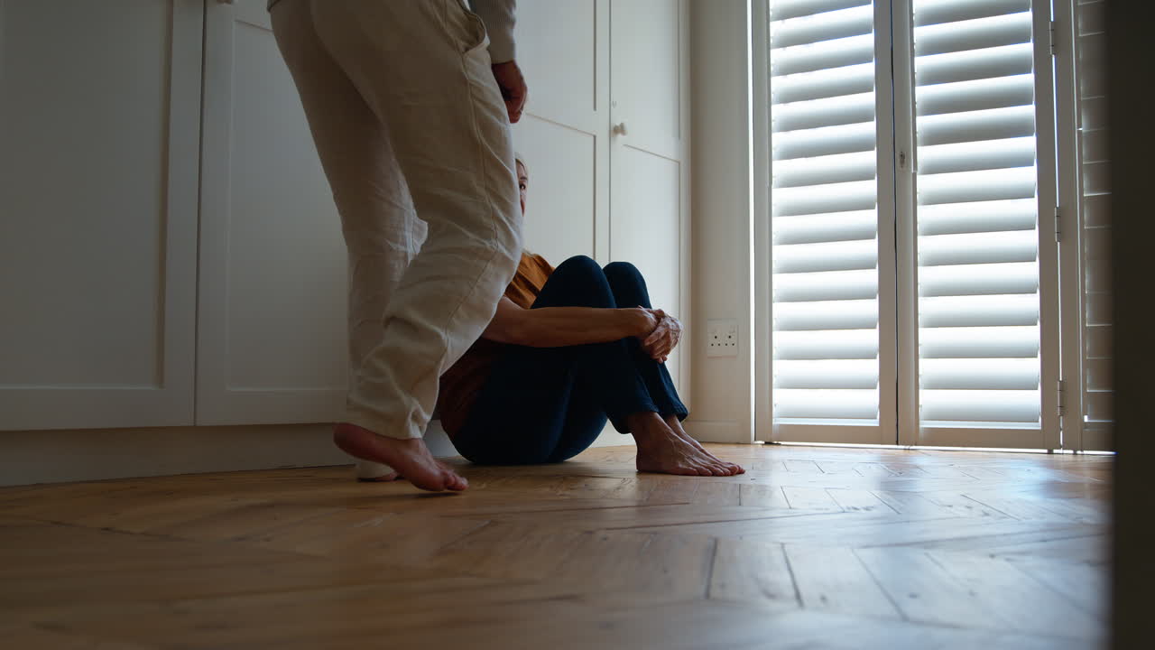 mujer mayor deprimida que sufre de mala salud mental siendo confortada por su marido en casa