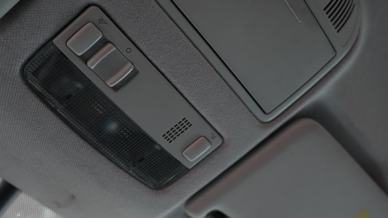 la mano del hombre caucásico apagando la luz interior del coche