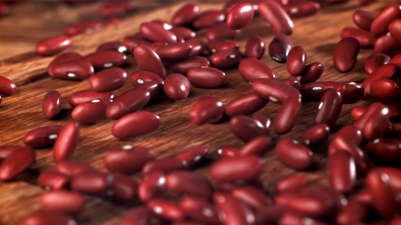 Red Kidney Beans Falling and Bouncing on a Wooden Surface in Slow Motion