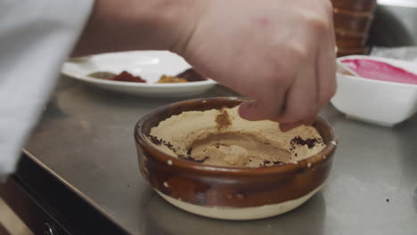 chef prepares mediterranean hummus starter dish