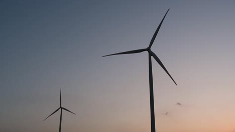 wind turbines silhouette against the blue-sky during sunset, clean alternative energy in thailand and mainland southeast asia