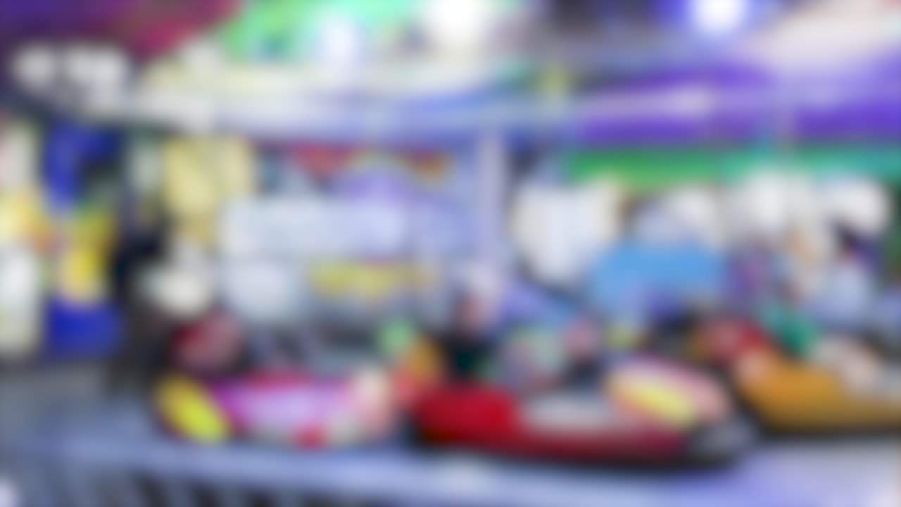 Vibrant bumper cars in motion under colorful lights at a lively nighttime carnival setting