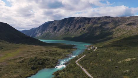 a breathtaking aerial view of a scenic landscape with a river, road, and mountains in innlandet near besseggen, norway