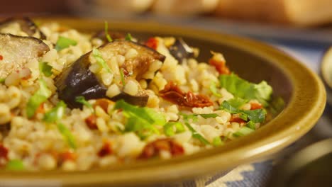 sprinkling greenery on bulgur with eggplant close-up. traditional middle eastern culture. delicious rice with meat. arabian cuisine. homemade food concept