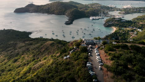 Toma-Aérea-Soleada-Del-Puerto-Inglés-En-Antigua,-Caribe-Con-Vistas-De-Yates,-Veleros,-Puerto-Deportivo,-Bahía-Y-Acantilados