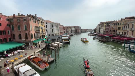 Amplia-Vista-Del-Gran-Canal-Desde-El-Famoso-Puente-De-Rialto,-Góndola-Navegando-Venecia-Italia