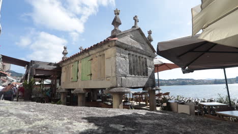 ancient stone hórreo in a coastal restaurant setting in combarro, galicia, spain