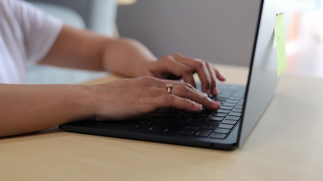 Mani di donna asiatica che digitano un'email o lavorano al laptop a casa. Primo piano.
