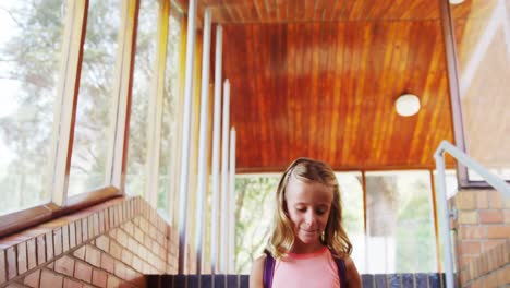 Schoolgirl-walking-on-staircase-at-school