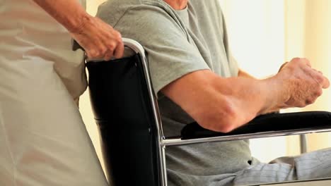 man in wheelchair looking through the window