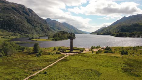 Aerial-Shot-Of-Scottish-Landmark-The-Glenfinnan-Monument,-With-Loch-Shiel-Behind,-Stunning-Scottish-Landscape,-Glenfinnan-In-The-Scottish-Highlands,-Scotland,-United-Kingdom