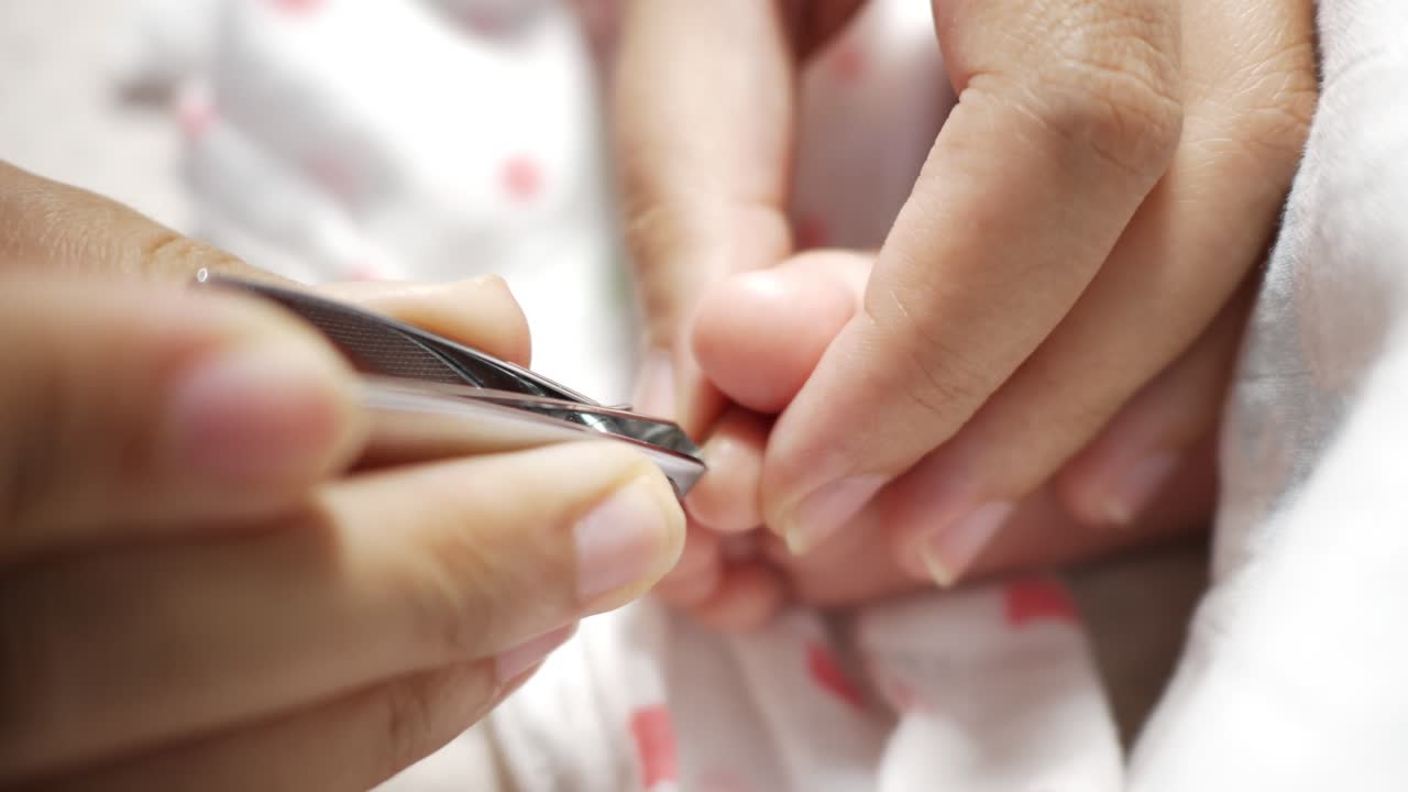 A caring moment as a girl carefully trims her baby's nails at home emphasizing love and attention.