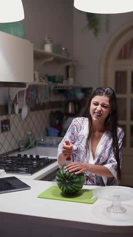 mujer cortando sandía en la cocina