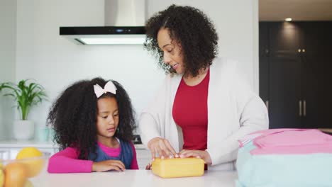 Glückliche-Afroamerikanische-Mutter-Packt-Lunchbox-Für-Tochter-Zur-Schule