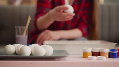 young woman takes egg to paint using ebru art technique