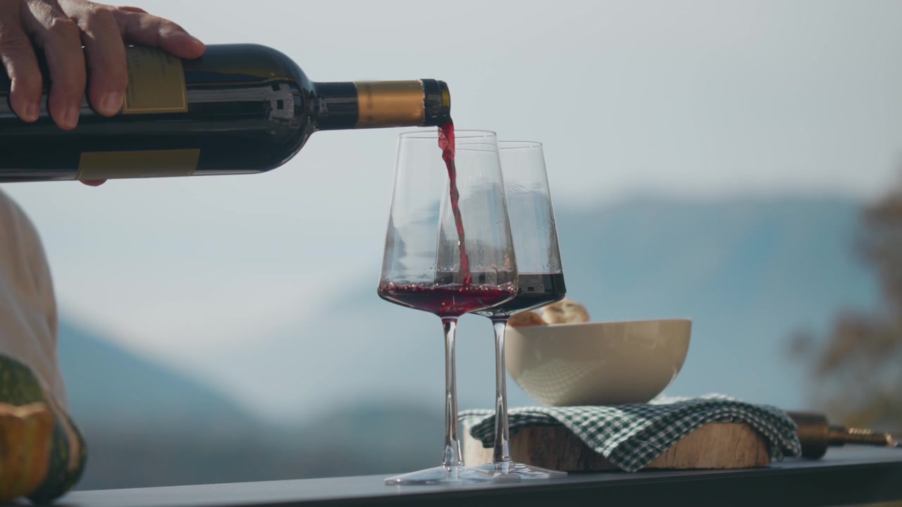 Pouring red wine into glass in outdoor space