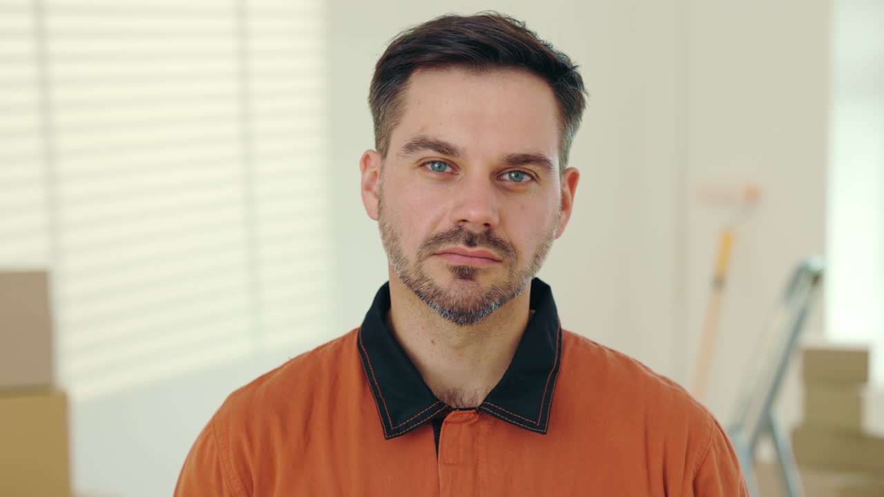 Uomo con camicia arancione che guarda dritto in camera