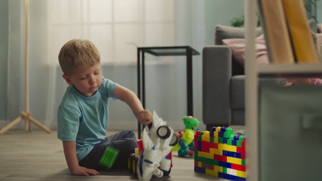 el niño juega con el avión mientras la hermana construye una casa